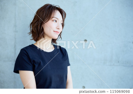 Woman sitting on a chair against a concrete background Woman sitting on a chair against a concrete background 115069098