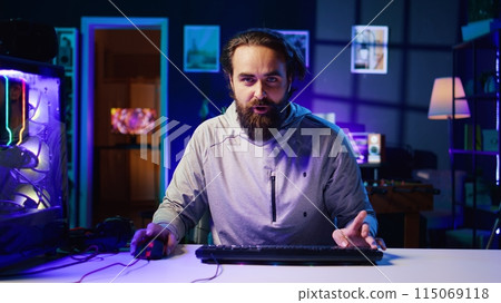 Content creator turning gaming chair around, greeting audience, filming tutorial on how to defeat enemies in multiplayer game. Pro gamer playing videogame, teaching viewers esports strategies Content creator turning gaming chair around, greeting audience, filming tutorial on how to defeat enemies in multiplayer game. Pro gamer playing videogame, teaching viewers esports strategies 115069118