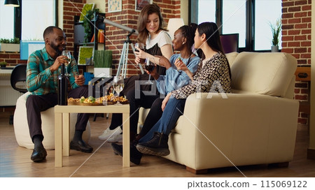 Culturally diverse group of people talking, drinking wine at friends social reunion. African american woman enjoying talking with mates, having fun together, eating snacks Culturally diverse group of people talking, drinking wine at friends social reunion. African american woman enjoying talking with mates, having fun together, eating snacks 115069122