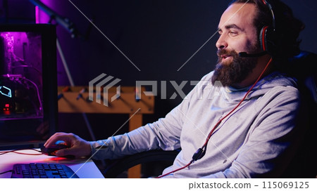 Man talking with friends online while playing singleplayer videogame with spaceship shooting laser bullets at asteroids. Gamer chats with teammates while hitting targets in SF game 115069125