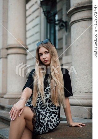 Young attractive woman sitting on the steps of an old building with columns 115072447