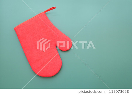 red wool winter glove on green background, christmas decoration red wool winter glove on green background, christmas decoration 115073638