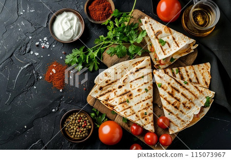 quesadillas with pepper, tomato, oil and salt on a dark background 115073967