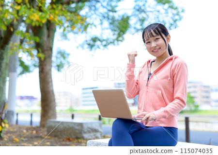 A woman using a computer outdoors in her free time Telework, Nomad work, Work style reform 115074035