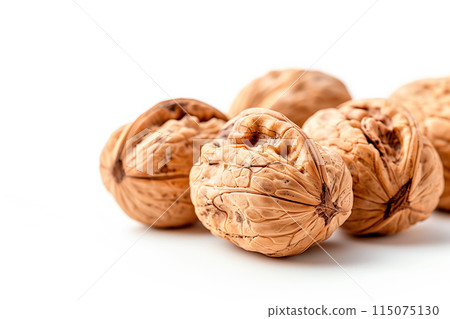 Close-up of shelled and unshelled Walnut nuts isolated on a white background, showcasing their texture 115075130