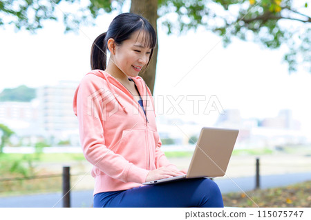 A woman working on a computer outdoors in her free time Telework, Nomad work, Work style reform, Trimming A woman working on a computer outdoors in her free time Telework, Nomad work, Work style reform, Trimming 115075747
