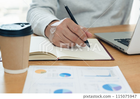 Hands of a man studying 115075947
