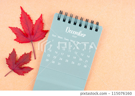 December 2024 monthly calendar and fall leaves on brown background. December 2024 monthly calendar and fall leaves on brown background. 115076160