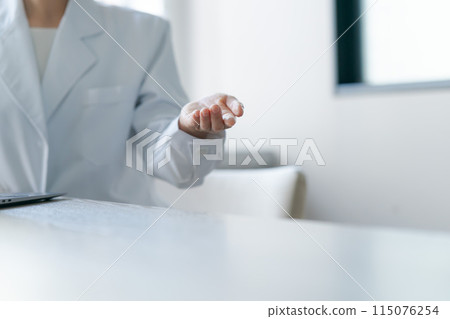 The hands of a woman wearing a white coat The hands of a woman wearing a white coat 115076254