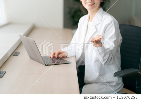 The hands of a woman wearing a white coat The hands of a woman wearing a white coat 115076255