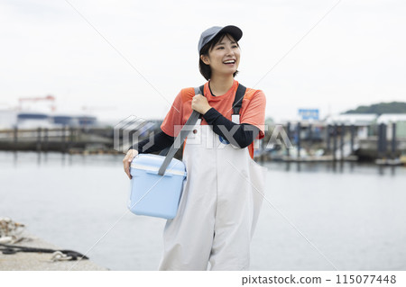 Young woman standing at a fishing port Young woman standing at a fishing port 115077448