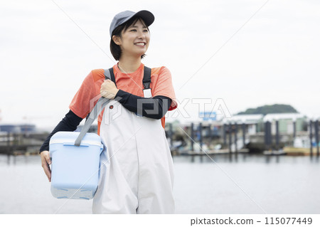 Young woman standing at a fishing port 115077449