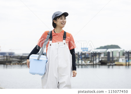 Young woman standing at a fishing port Young woman standing at a fishing port 115077450