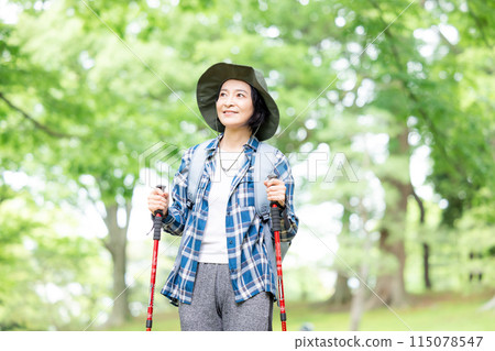 Middle-aged woman enjoying hiking Middle-aged woman enjoying hiking 115078547