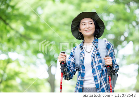 Middle-aged woman enjoying hiking Middle-aged woman enjoying hiking 115078548