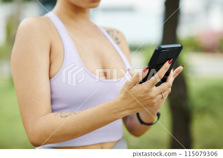 Woman Using Smartphone During Outdoor Activity Woman Using Smartphone During Outdoor Activity 115079306
