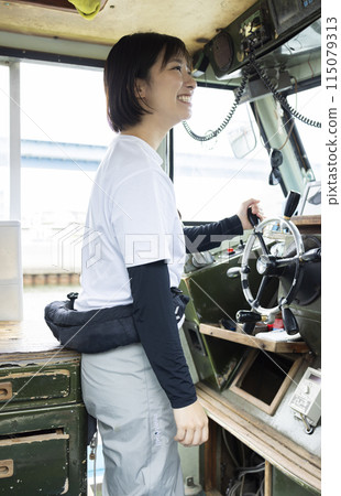 Young woman steering a boat 115079313
