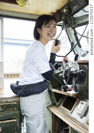 Young woman steering a boat Young woman steering a boat 115079317