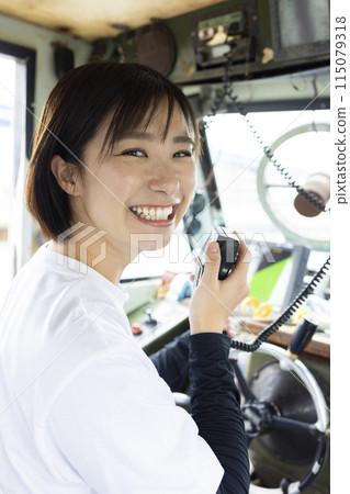 Young woman steering a boat 115079318