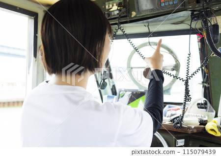 Young woman steering a boat Young woman steering a boat 115079439