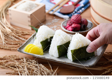 剛煮好的飯糰,裡麵包裹著海苔、米和酸梅,呈方形 剛煮好的飯糰,裡麵包裹著海苔、米和酸梅,呈方形 115080149