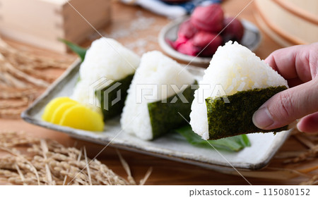 剛煮好的飯糰,裡麵包裹著海苔、米和酸梅,呈方形 剛煮好的飯糰,裡麵包裹著海苔、米和酸梅,呈方形 115080152