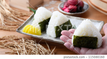 Freshly cooked rice wrapped in seaweed and rice and pickled plums served in a wooden box 115080160