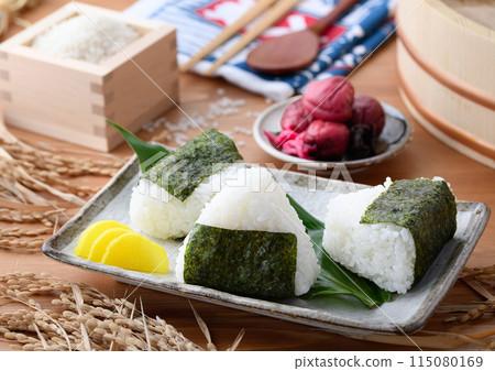 剛煮好的飯糰,裡麵包裹著海苔、米和酸梅,呈方形 剛煮好的飯糰,裡麵包裹著海苔、米和酸梅,呈方形 115080169