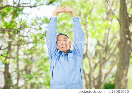 Man in work clothes stretching 115081620