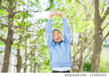 Man in work clothes stretching Man in work clothes stretching 115081622