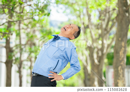 Man in work clothes stretching Man in work clothes stretching 115081628