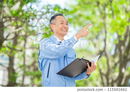 Man in work clothes, clipboard, pointing 115081662