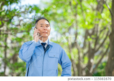 穿著工作服的男人用智慧型手機交談 穿著工作服的男人用智慧型手機交談 115081670