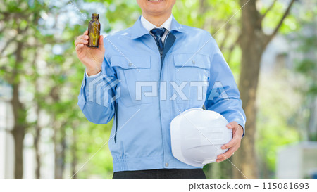 Man in work clothes, energy drink, no face Man in work clothes, energy drink, no face 115081693