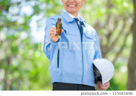 Man in work clothes, energy drink, no face 115081696