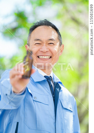 Man in work clothes, energy drink, vertical Man in work clothes, energy drink, vertical 115081699