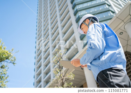 Man in work clothes, office building, tablet, back view Man in work clothes, office building, tablet, back view 115081771