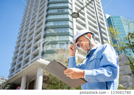 Man in work clothes, office building, tablet, worried Man in work clothes, office building, tablet, worried 115081780