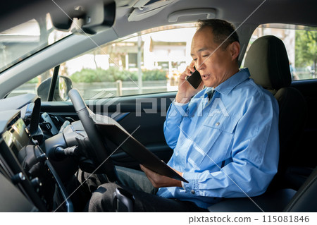 Man in work clothes, car, smartphone 115081846