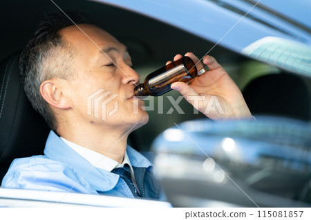 Man in work clothes, car, energy drink 115081857