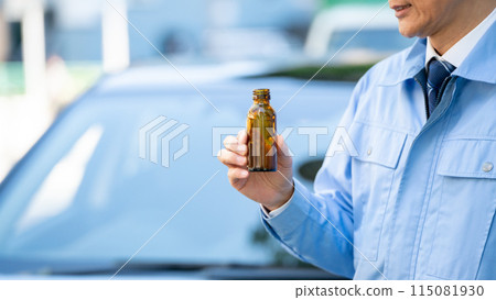 Man in work clothes, outside of car, energy drink, close-up 115081930