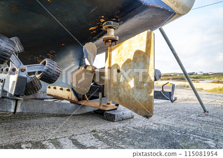 Propeller screw and rudder of vessel at Rosbeg harbour in County Donegal - Ireland. Propeller screw and rudder of vessel at Rosbeg harbour in County Donegal - Ireland. 115081954
