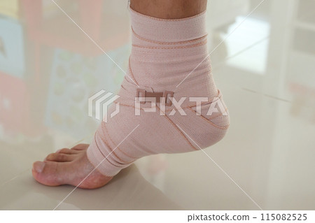 Man with ankle sprain elastic bandage for ankle injury and feeling pain Man with ankle sprain elastic bandage for ankle injury and feeling pain 115082525