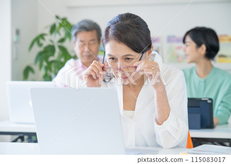 Senior woman with presbyopia having difficulty seeing a computer screen Senior woman with presbyopia having difficulty seeing a computer screen 115083017