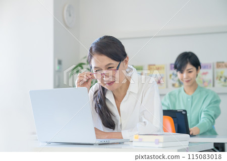 一位因遠視而看清電腦螢幕有困難的老年婦女 一位因遠視而看清電腦螢幕有困難的老年婦女 115083018