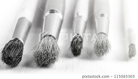 Brush set for artist on white wooden background on sunlight 115083303