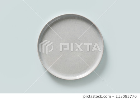 Empty blue plate isolated on blue culinary background. Kitchen and cooking template, mock up. View from above. Empty blue plate isolated on blue culinary background. Kitchen and cooking template, mock up. View from above. 115083776