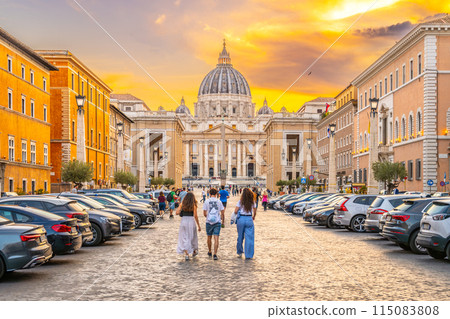A group of tourists walk towards the Vatican City along the Road of Conciliation during a golden sunset. A group of tourists walk towards the Vatican City along the Road of Conciliation during a golden sunset. 115083808