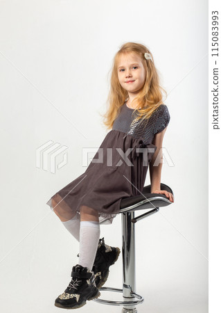 A little blonde girl in a leather jacket and a black hat 115083993