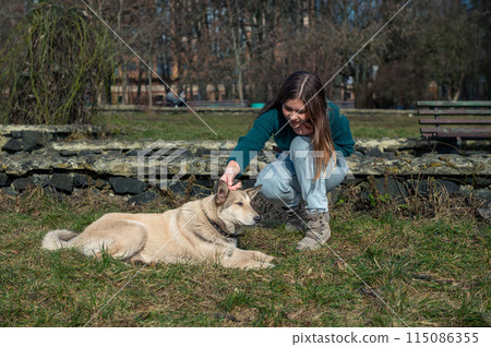 Beautiful teen girl with dog. Teenage girl playing with a dog in the park. Beautiful teen girl with dog. Teenage girl playing with a dog in the park. 115086355